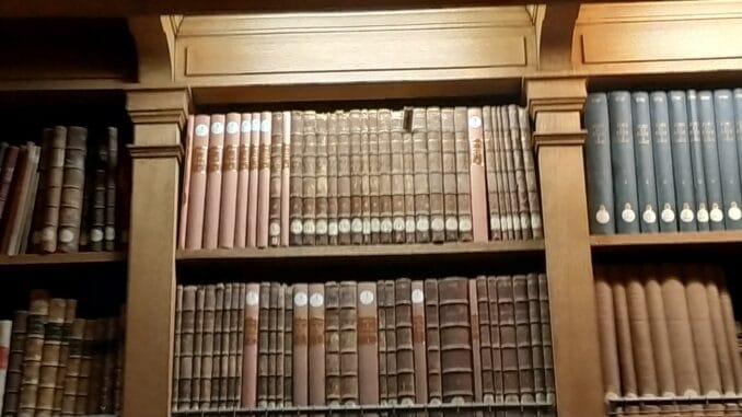 réédition du livre par Jehan Nomis Étagère de bibliothèque contenant des livres anciens et des collections rares.