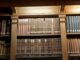 Étagère de bibliothèque contenant des livres anciens et des collections rares.