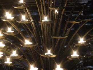 Une structure de candelabre avec de multiples bougies illuminées, symbolisant le chemin de la lumière et de la connaissance en Franc-maçonnerie.