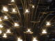 Une structure de candelabre avec de multiples bougies illuminées, symbolisant le chemin de la lumière et de la connaissance en Franc-maçonnerie.