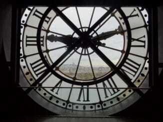 Une horloge avec des chiffres romains, donnant sur une ville.