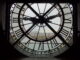 Une horloge avec des chiffres romains, donnant sur une ville.