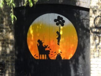 Peinture murale d'une silhouette s'élevant avec des ballons sur fond de coucher de soleil, évoquant l'éveil spirituel en lien avec la franc-maçonnerie.