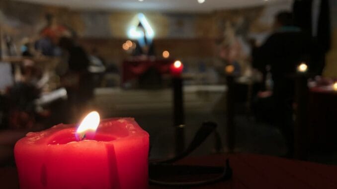 Lueur Mystique Une bougie rouge illuminant paisiblement une salle aux lumières douces, invitant à la contemplation.