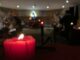 Une bougie rouge illuminant paisiblement une salle aux lumières douces, invitant à la contemplation.
